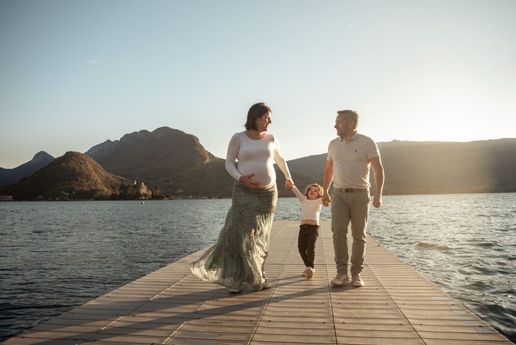 maman enceinte se promenant avec son mari et sa fille au lac d'Annecy