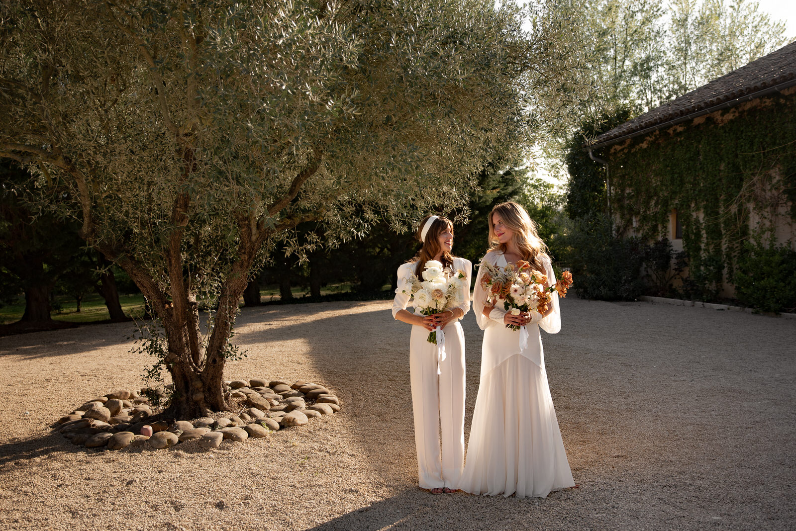 couple de mariés posant devant un olivier